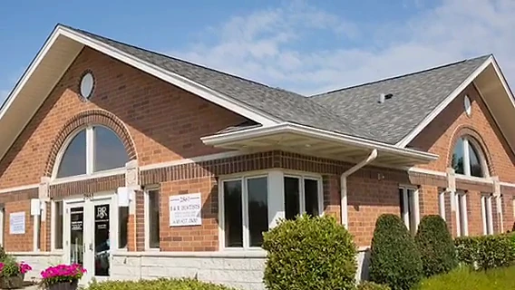 The B&R Dentists building at 2861 83rd St. in Darien, a single-storey brick building with an arched front window and the practice name on the glass door.